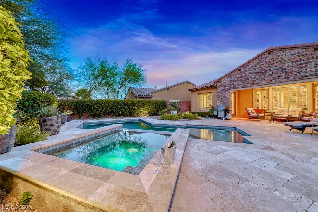 41 Moltrasio Lane, Henderson, NV 89011 An inviting backyard oasis features a tiled swimming pool and integrated spa surrounded by stone pavers.