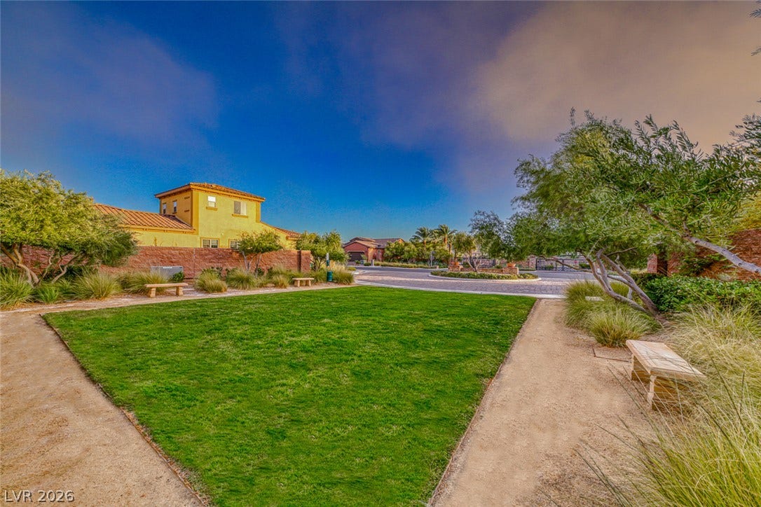 41 Moltrasio Lane, Henderson, NV 89011 A manicured green lawn and stone benches line the neighborhood walking path.