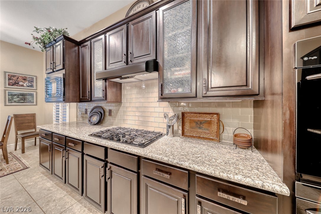 41 Moltrasio Lane, Henderson, NV 89011 Gleaming granite countertops pair beautifully with rich dark cabinetry and a classic tile backsplash.