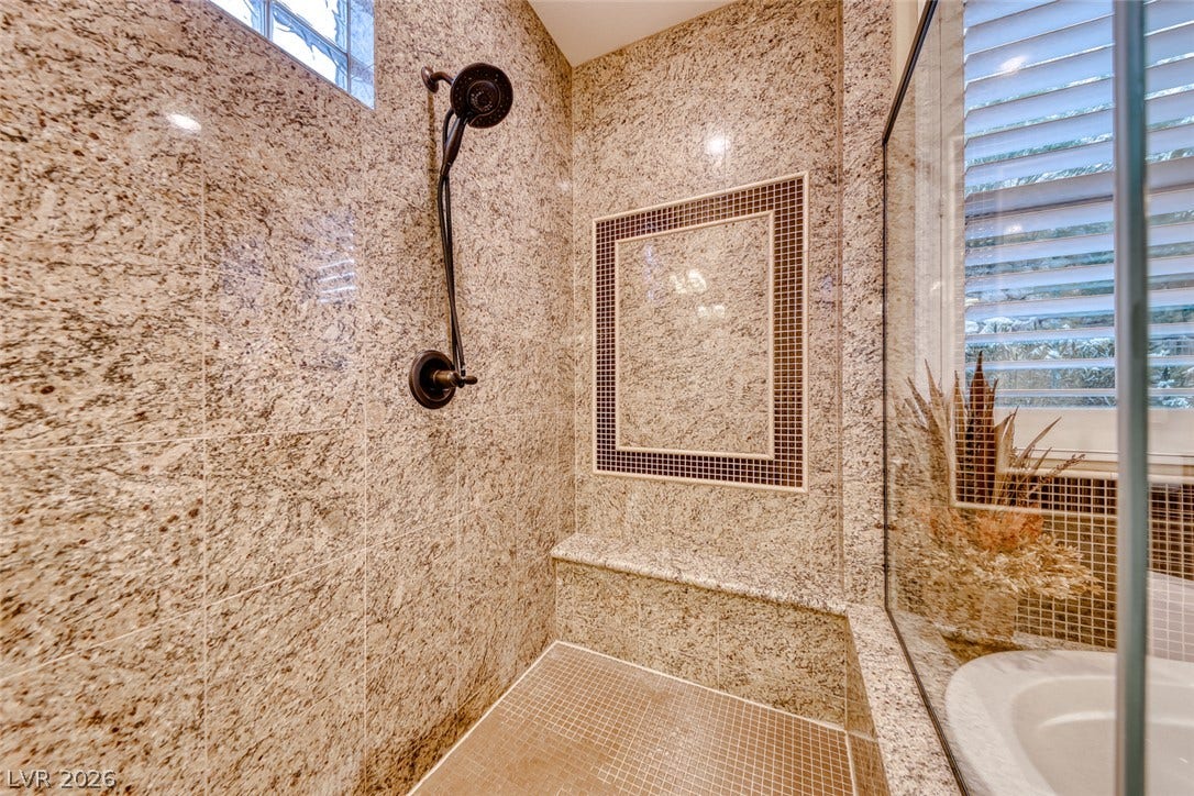 41 Moltrasio Lane, Henderson, NV 89011 Polished stone walls and a built-in bench elevate this walk-in shower.
