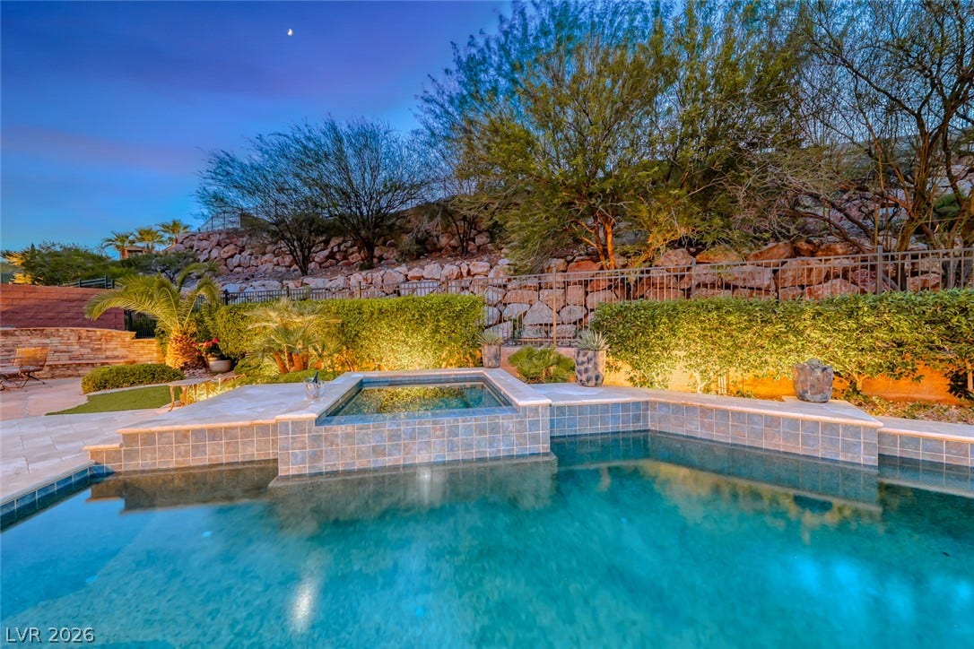 41 Moltrasio Lane, Henderson, NV 89011 A sparkling pool and raised spa rest against a terraced stone landscape.