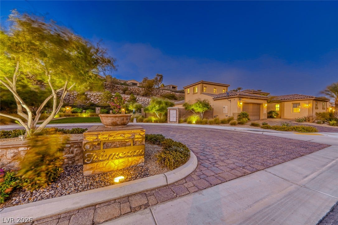 41 Moltrasio Lane, Henderson, NV 89011 An inviting gated community entrance features paved roadways and warm exterior lighting.