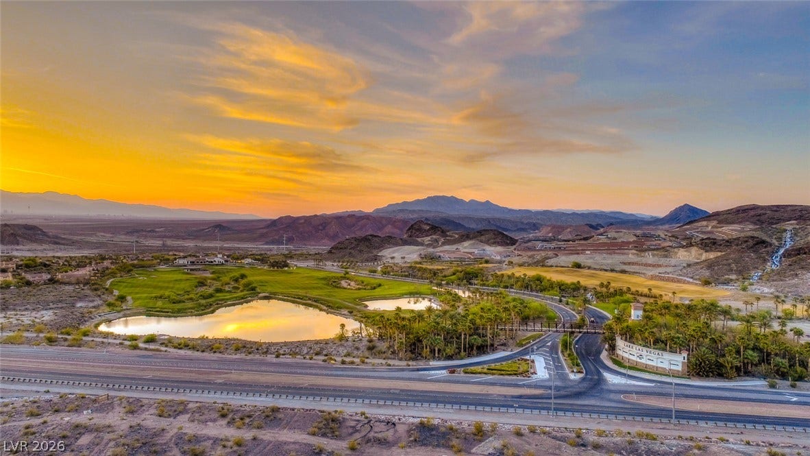 41 Moltrasio Lane, Henderson, NV 89011 Dramatic mountain and water views unfold across this serene desert landscape under vibrant sunset skies.