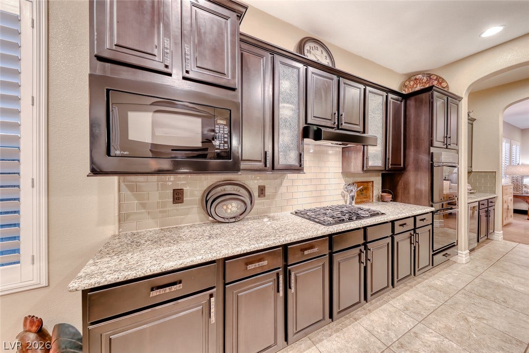41 Moltrasio Lane, Henderson, NV 89011 Rich dark cabinetry and polished stone countertops elevate this culinary workspace.