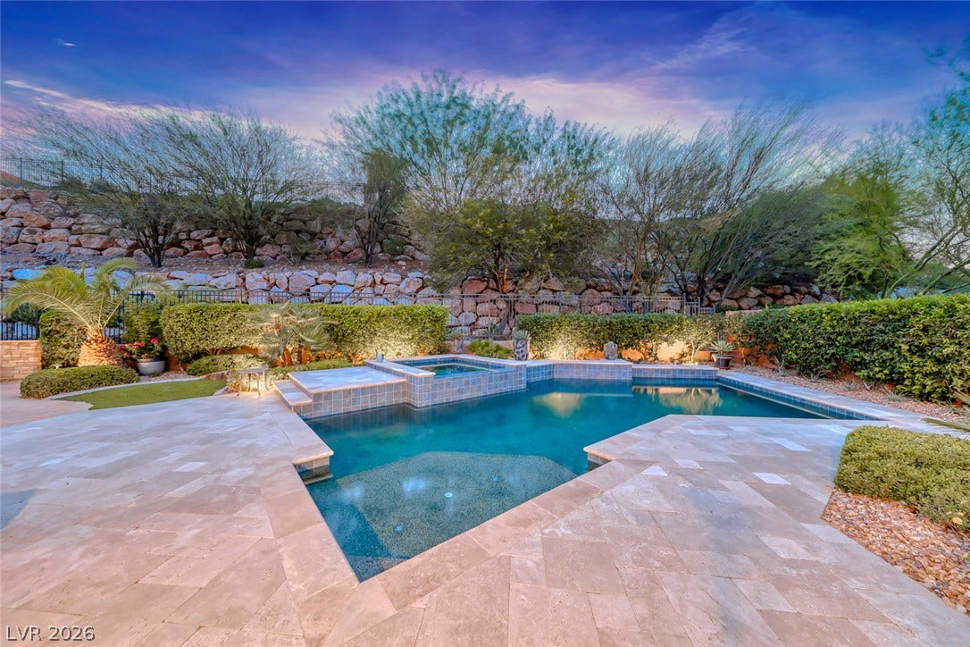 41 Moltrasio Lane, Henderson, NV 89011 An inviting backyard oasis features a shimmering custom pool bordered by stone pavers.