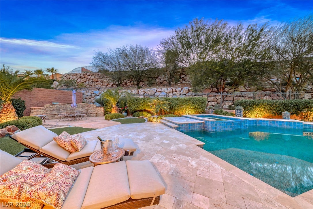 41 Moltrasio Lane, Henderson, NV 89011 A stone-tiled terrace surrounds the sparkling pool, bordered by professional desert landscaping and rock walls.