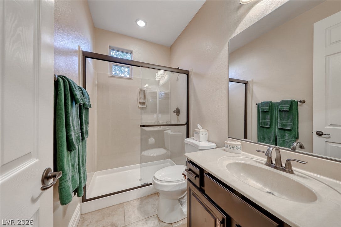 41 Moltrasio Lane, Henderson, NV 89011 A glass-enclosed walk-in shower and stone-look tile flooring elevate this functional bathroom.