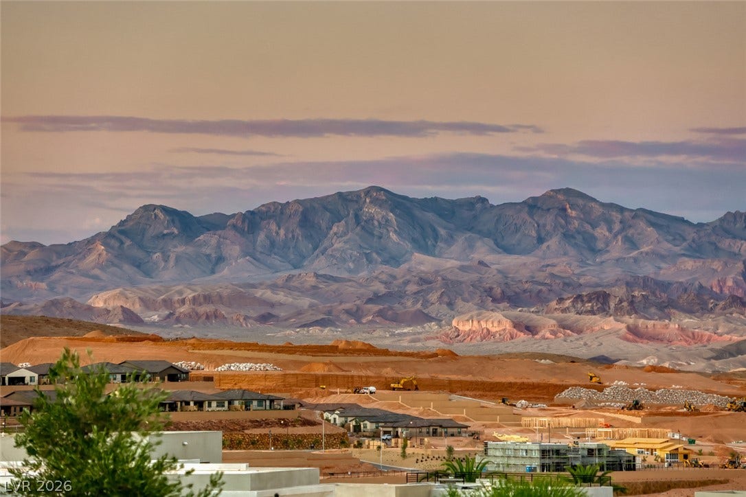 41 Moltrasio Lane, Henderson, NV 89011 Rugged ridges frame a peaceful residential valley under a soft evening sky.