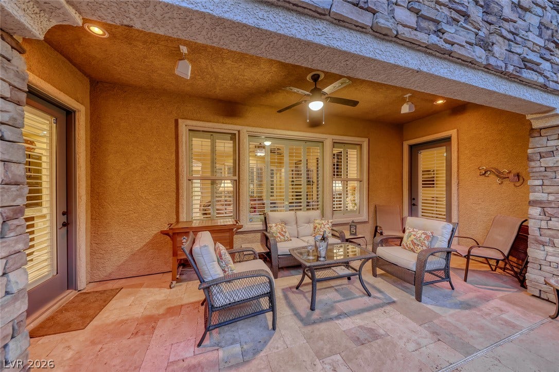 41 Moltrasio Lane, Henderson, NV 89011 Stone pillars frame a sheltered outdoor living space featuring tiled flooring and integrated lighting.