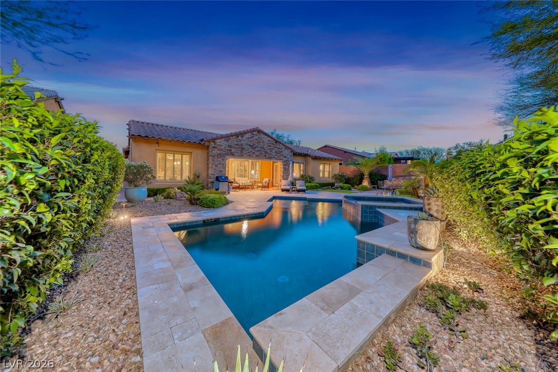41 Moltrasio Lane, Henderson, NV 89011 A sparkling geometric pool anchors this beautifully landscaped backyard setting under twilight skies.