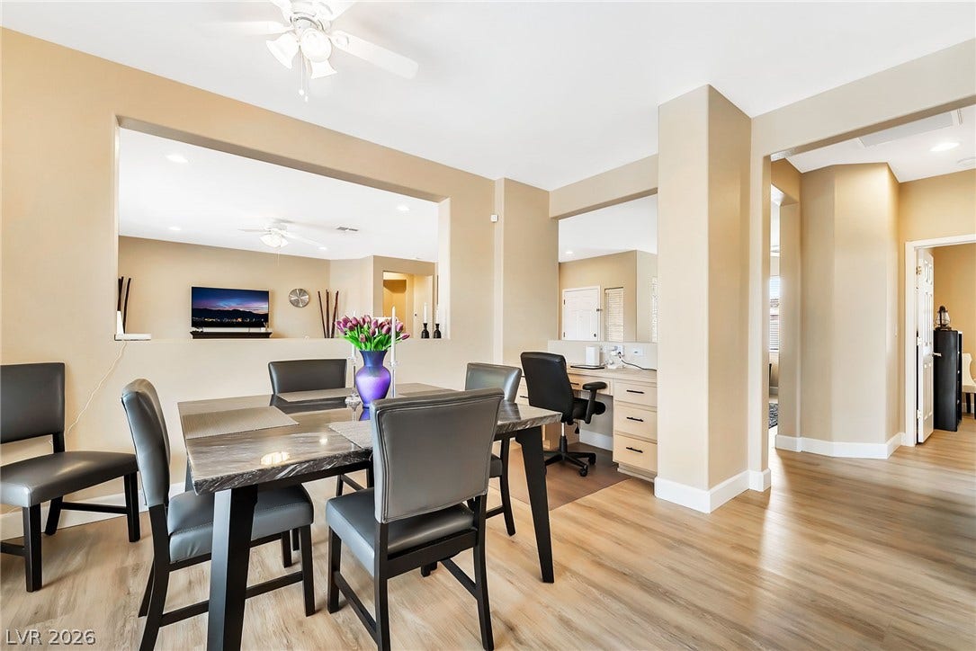 Warm hardwood floors complement the seamless layout connecting the dining space and built-in home office.