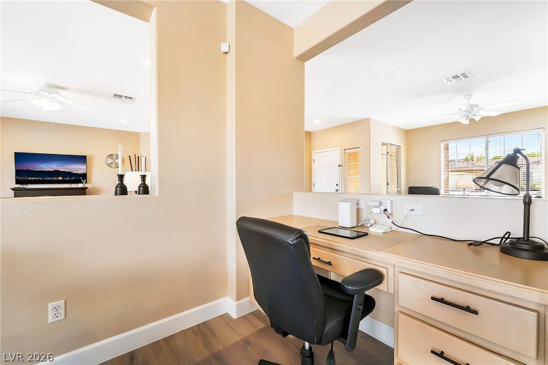 A built-in workspace overlooks the open living areas through architectural wall cutouts.
