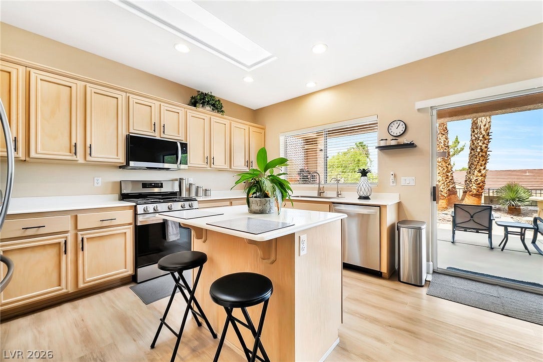 A spacious culinary space highlights wooden cabinetry and a central prep island.