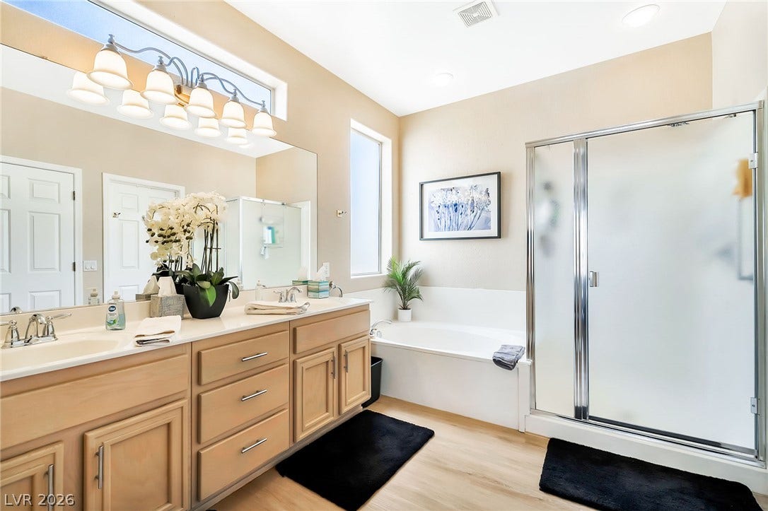 Natural light pours over the soaking tub and spacious vanity setup in this clean bathroom.