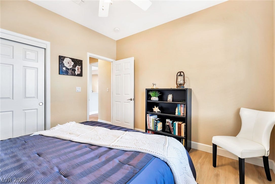 Smooth wood floors and tall ceilings anchor this quiet bedroom space.