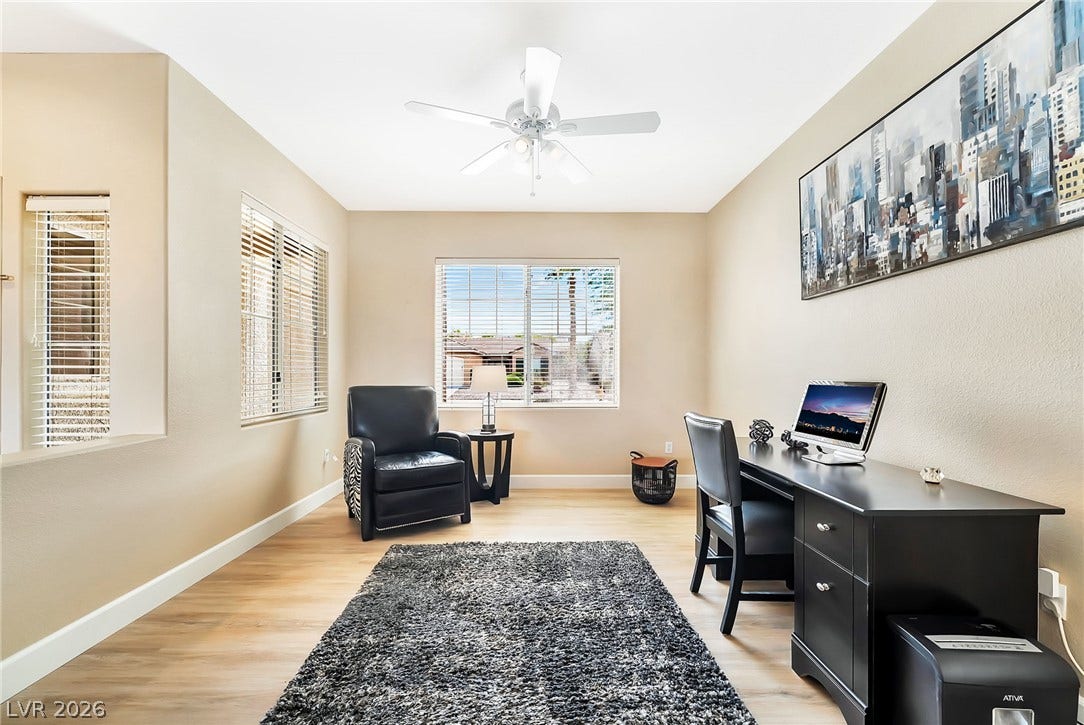 Warm wood flooring and natural light through multiple windows create an inviting, productive workspace.