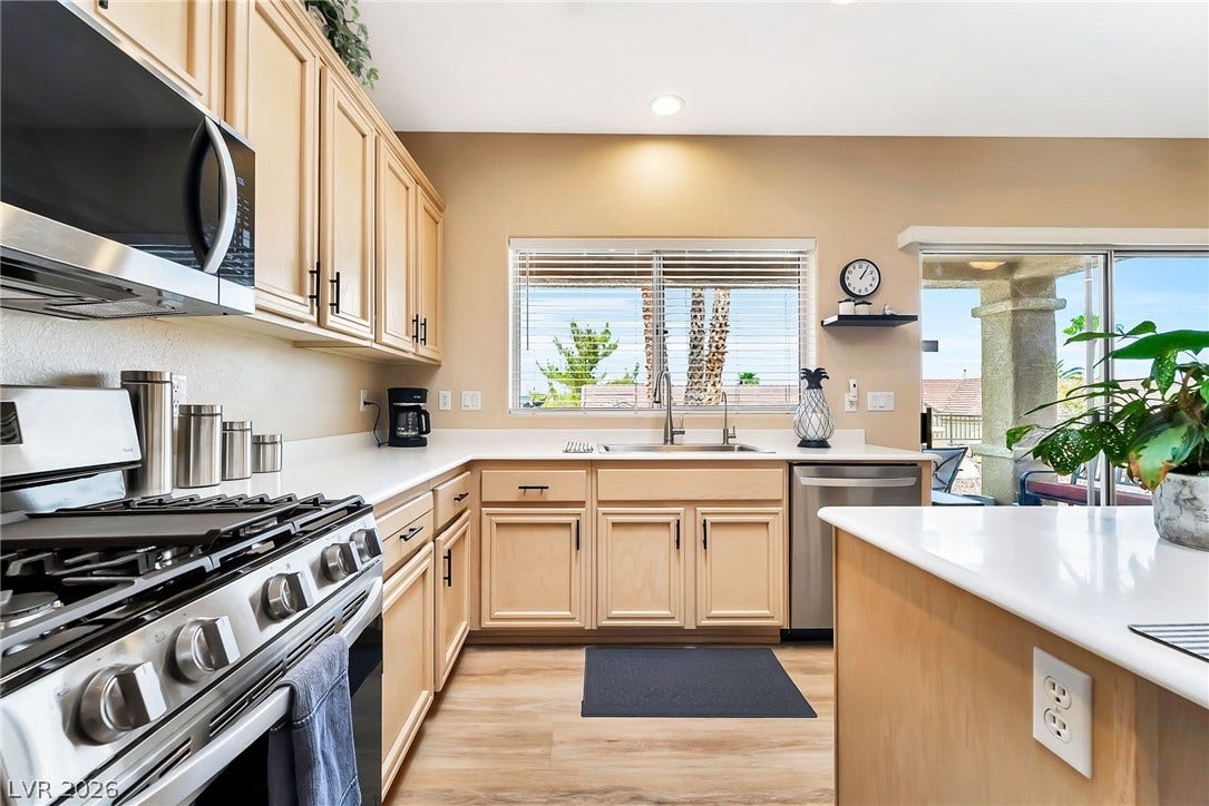 Warm wood cabinetry and durable solid-surface countertops anchor this functional workspace.