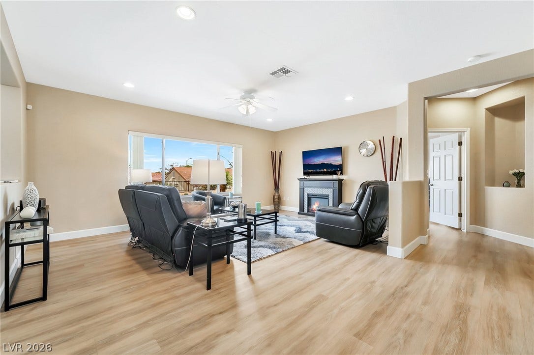 Smooth wood floors flow through this welcoming living space featuring an elegant electric fireplace.
