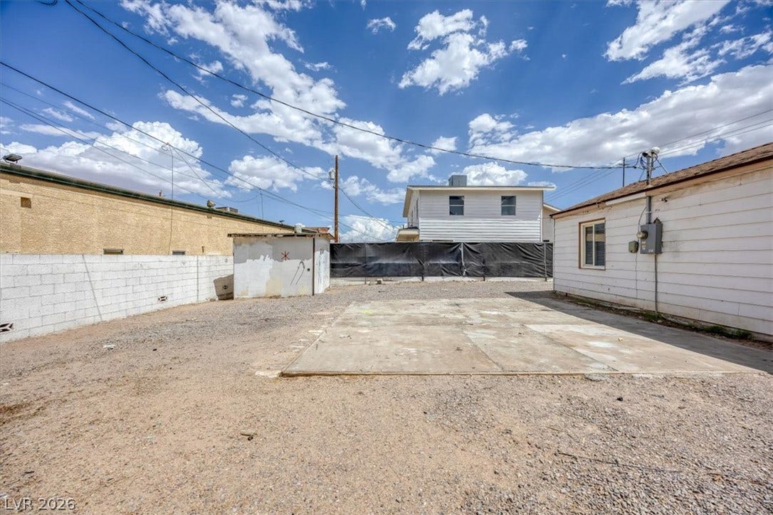 120 W Victory Road, Henderson, NV 89015 An open gravel yard features a concrete pad flanked by versatile outbuildings and perimeter walls.