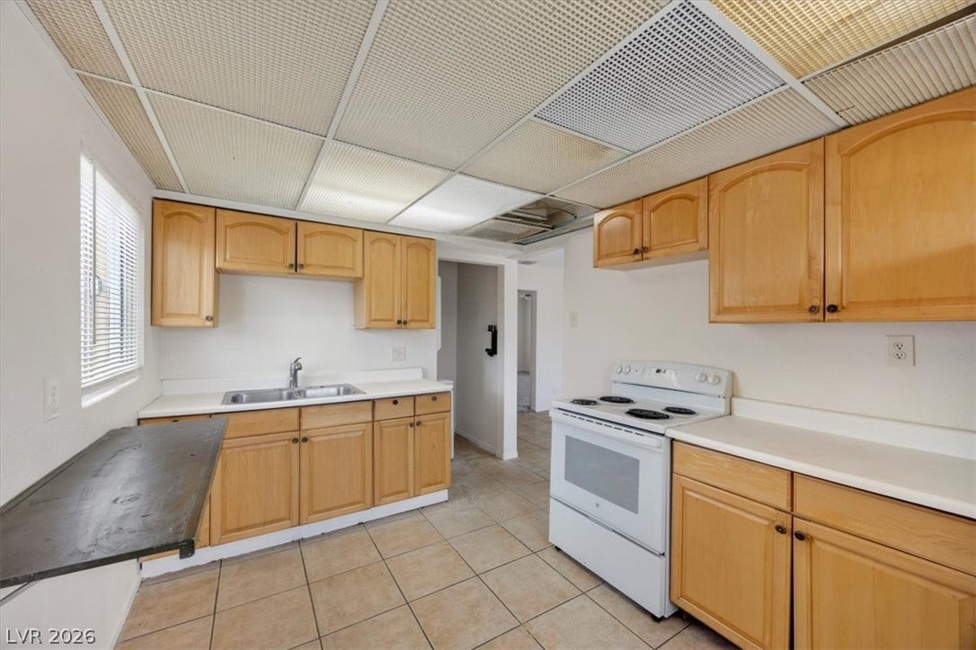 120 W Victory Road, Henderson, NV 89015 Functional kitchen design with tile flooring and wood cabinets awaiting custom updates.