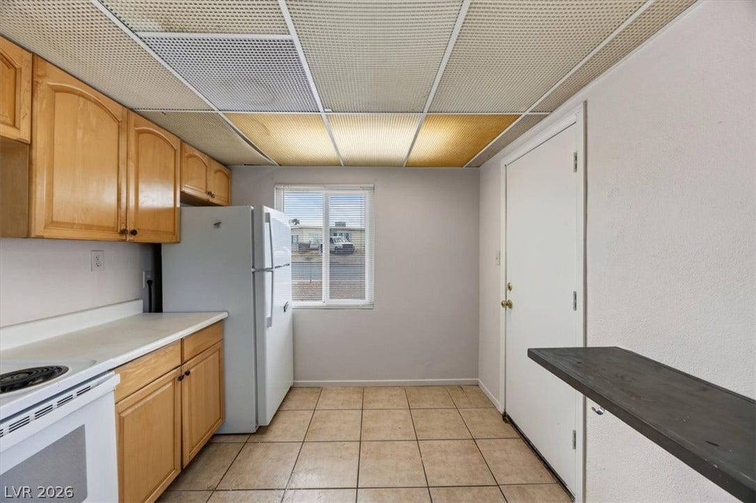 120 W Victory Road, Henderson, NV 89015 Functional kitchen design with durable tiled flooring and classic wood cabinetry.