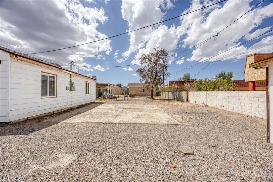 120 W Victory Road, Henderson, NV 89015 An expansive gravel yard features a concrete pad flanked by block and wood fencing.