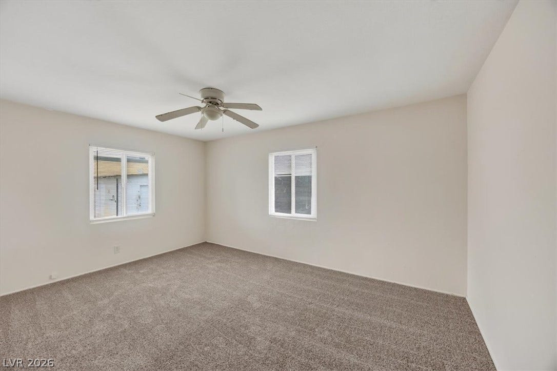 120 W Victory Road, Henderson, NV 89015 Plush carpeting anchors this versatile room under a smooth ceiling with dual windows.