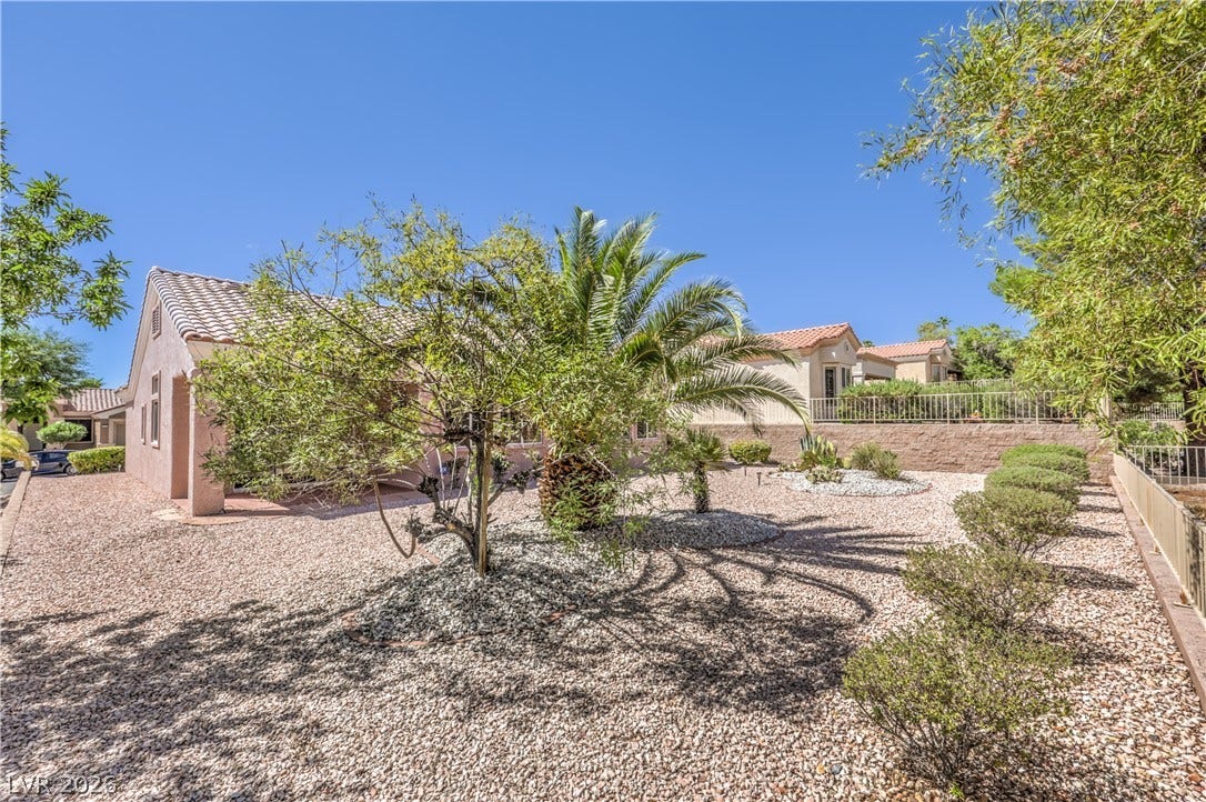 10700 Grand Cypress Avenue, Las Vegas, NV 89134 Lush desert landscaping and mature palms frame this beautifully constructed tile-roof residence.