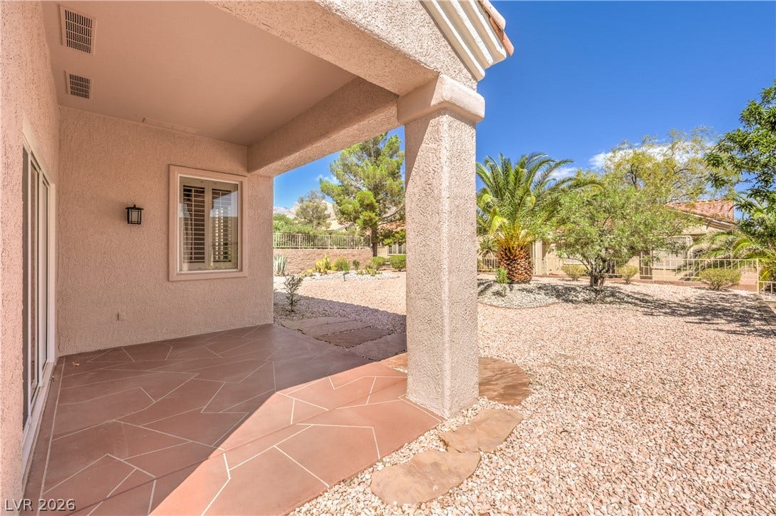 10700 Grand Cypress Avenue, Las Vegas, NV 89134 A covered patio with stone flooring overlooks the low-maintenance desert landscape.