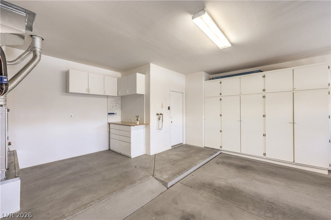 10700 Grand Cypress Avenue, Las Vegas, NV 89134 Concrete flooring and abundant built-in storage cabinets define this highly functional garage space.