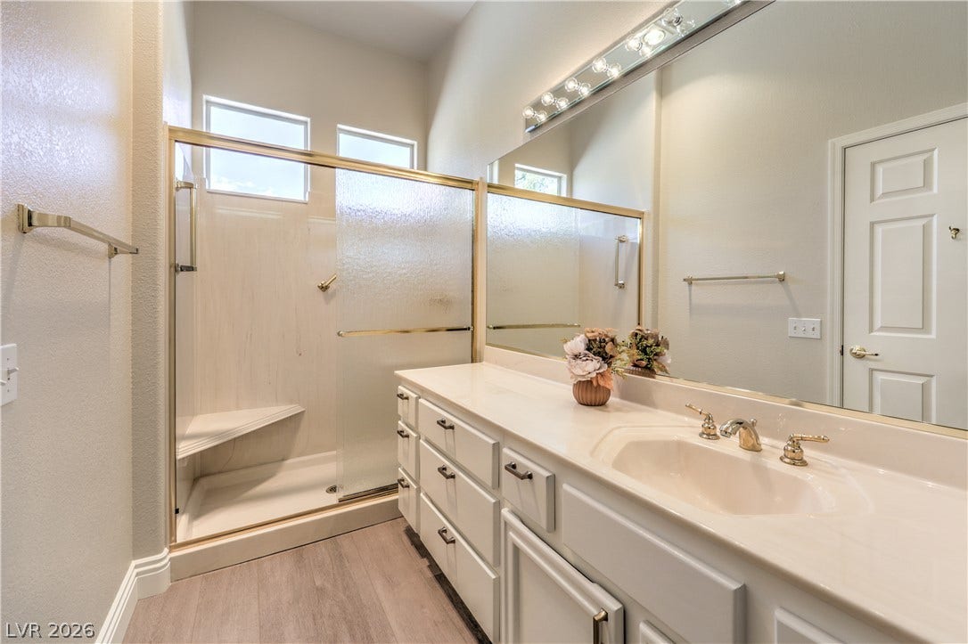 10700 Grand Cypress Avenue, Las Vegas, NV 89134 High ceilings and a glass-enclosed shower highlight this sleek bathroom space.