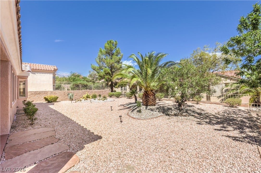 10700 Grand Cypress Avenue, Las Vegas, NV 89134 Lush palm trees and desert landscaping frame this low-maintenance private yard.