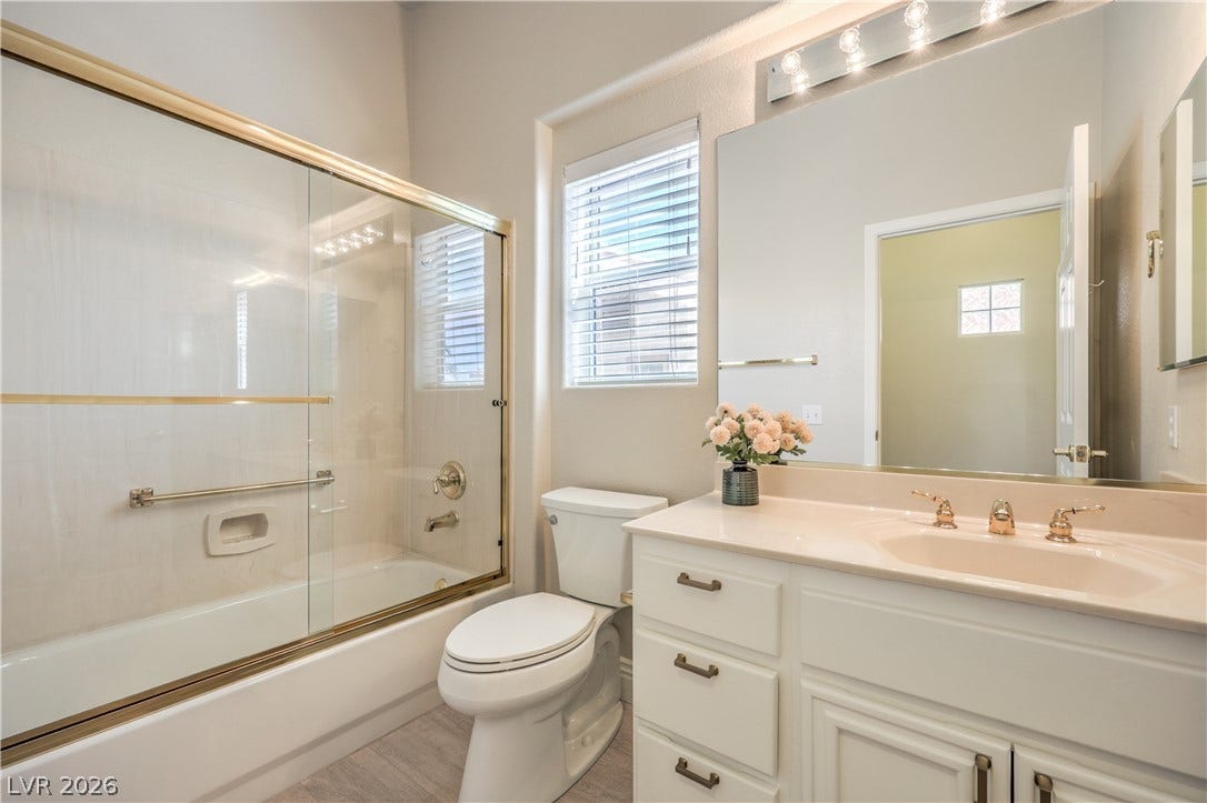 10700 Grand Cypress Avenue, Las Vegas, NV 89134 An elegant tub shower pairing sits adjacent to a classic single vanity with clean finishes.