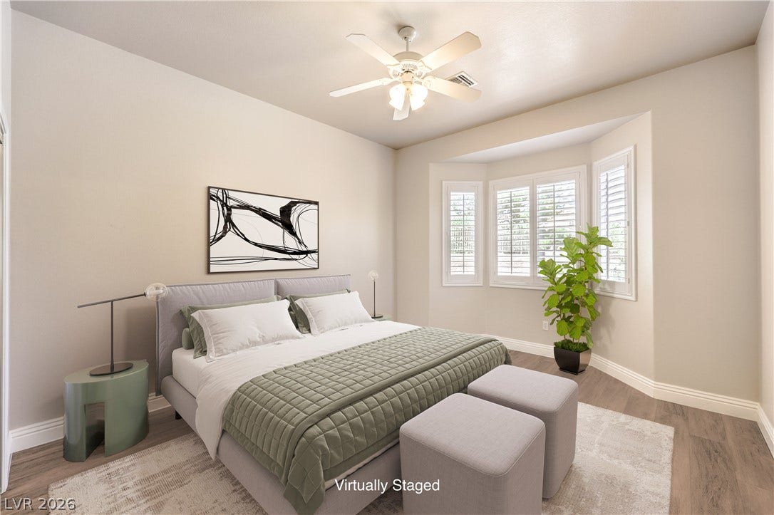 10700 Grand Cypress Avenue, Las Vegas, NV 89134 An elegant bay window with classic plantation shutters highlights this airy bedroom retreat.