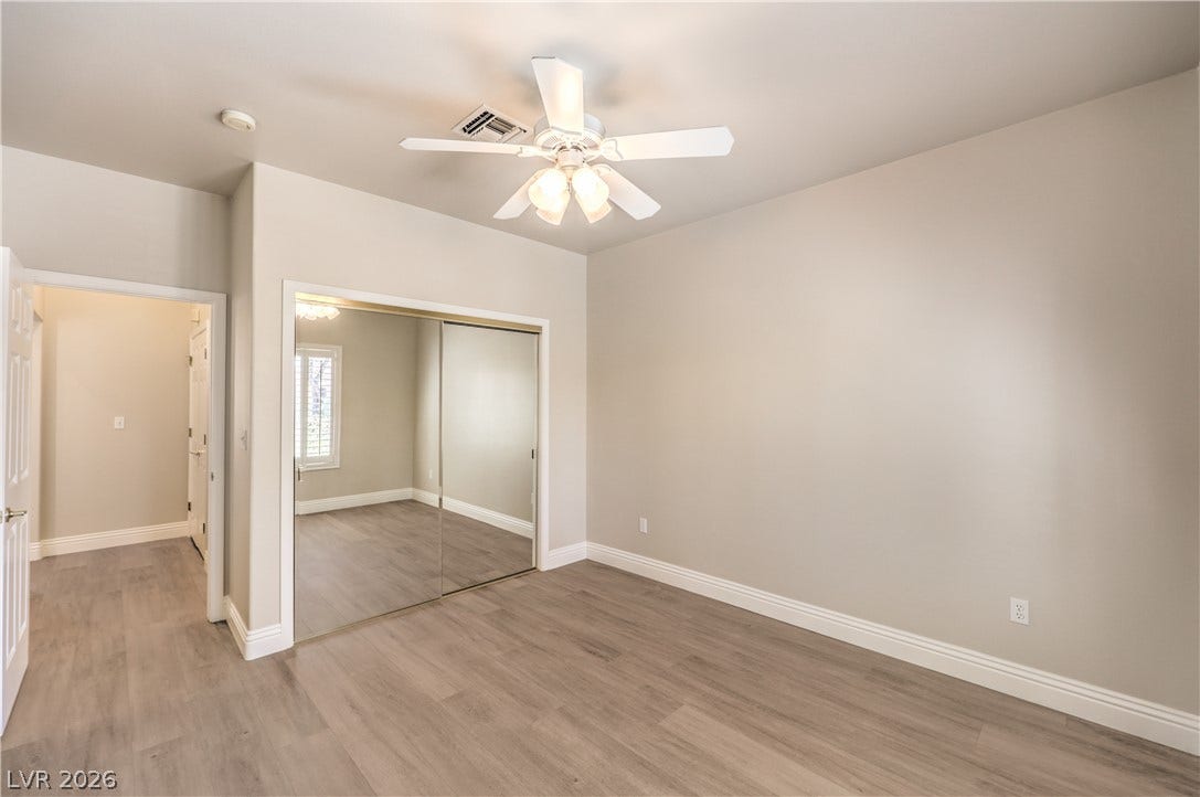 10700 Grand Cypress Avenue, Las Vegas, NV 89134 Smooth wood-look flooring and a mirrored closet door define this versatile bedroom space.
