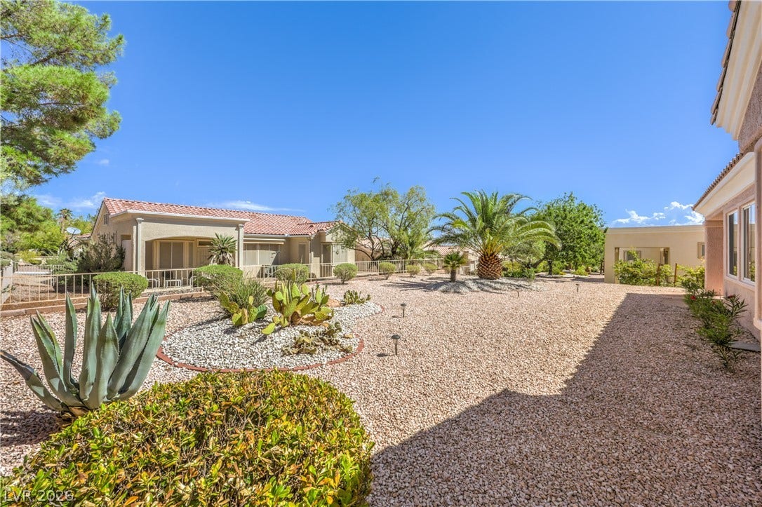 10700 Grand Cypress Avenue, Las Vegas, NV 89134 Desert landscaping and mature palms create a low-maintenance outdoor space under clear blue skies.