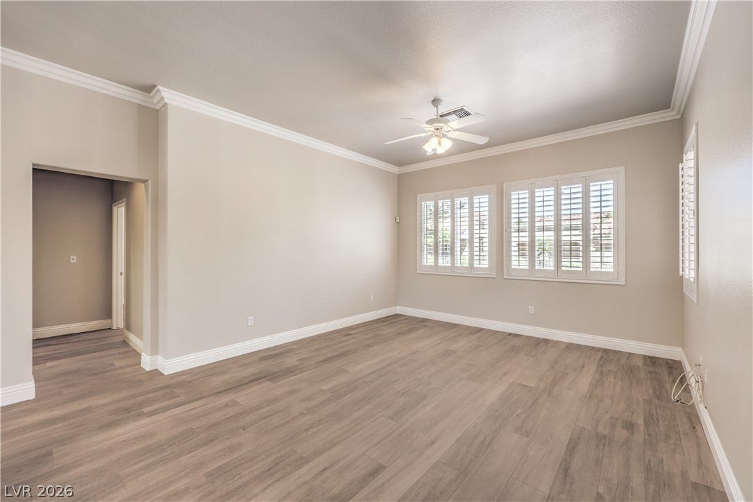 10700 Grand Cypress Avenue, Las Vegas, NV 89134 Classic crown molding and plantation shutters frame this versatile living space.