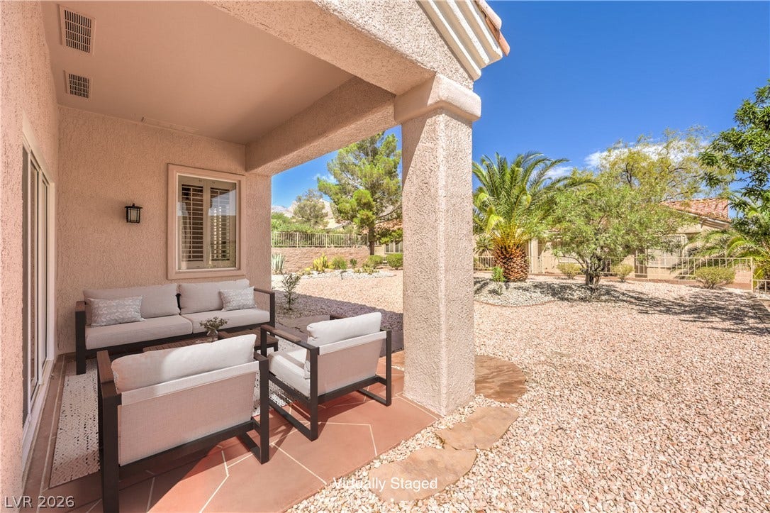10700 Grand Cypress Avenue, Las Vegas, NV 89134 Shaded tile patio looks out over a low-maintenance desert landscape under clear blue skies.