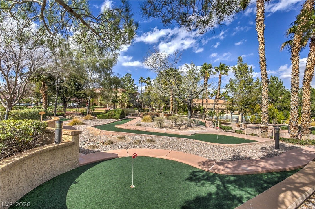 10700 Grand Cypress Avenue, Las Vegas, NV 89134 Lush desert landscaping surrounds this community putting green under a bright, cloud-filled sky.