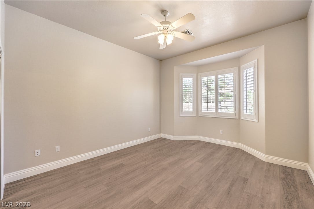10700 Grand Cypress Avenue, Las Vegas, NV 89134 Smooth wood floors anchor this clean space featuring an elegant bay window with custom shutters.