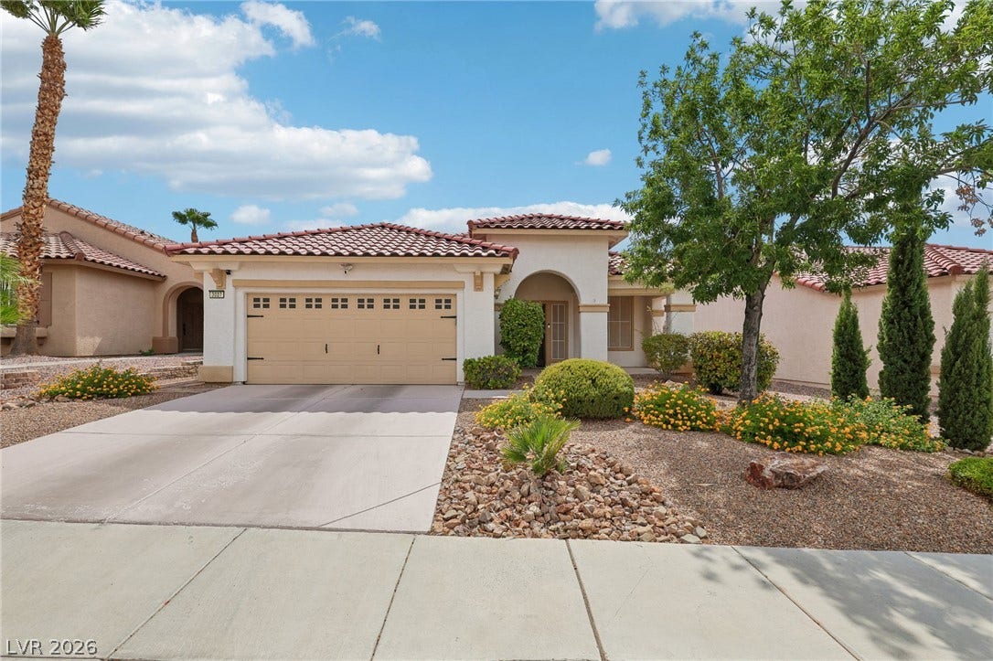 3027 Panorama Ridge Drive, Henderson, NV 89052 Spanish tile roofing and desert-friendly landscaping frame this charming single-story exterior.