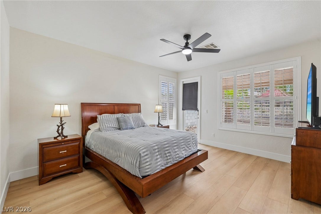 3027 Panorama Ridge Drive, Henderson, NV 89052 Warm wood-like flooring and classic shutters define this inviting bedroom space.