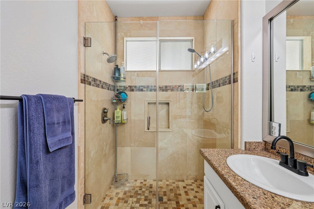 3027 Panorama Ridge Drive, Henderson, NV 89052 Tiled walk-in shower features glass doors and integrated stone finishes.