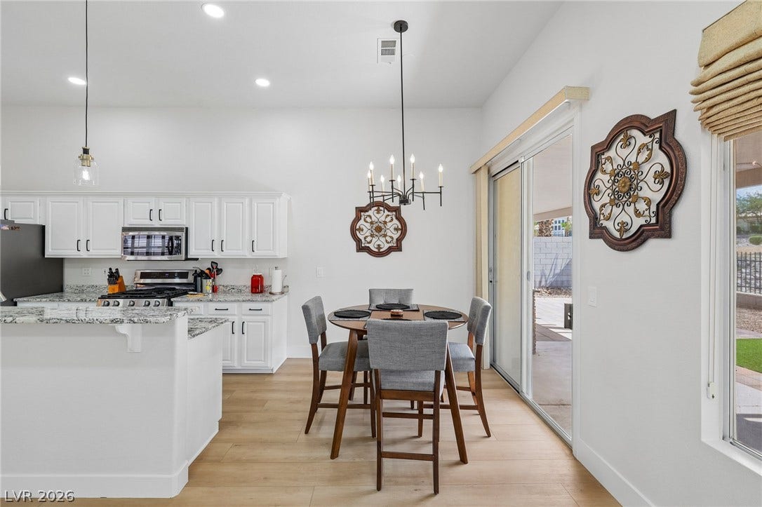 3027 Panorama Ridge Drive, Henderson, NV 89052 Sliding glass doors open from the dining area to a sunlit backyard patio.