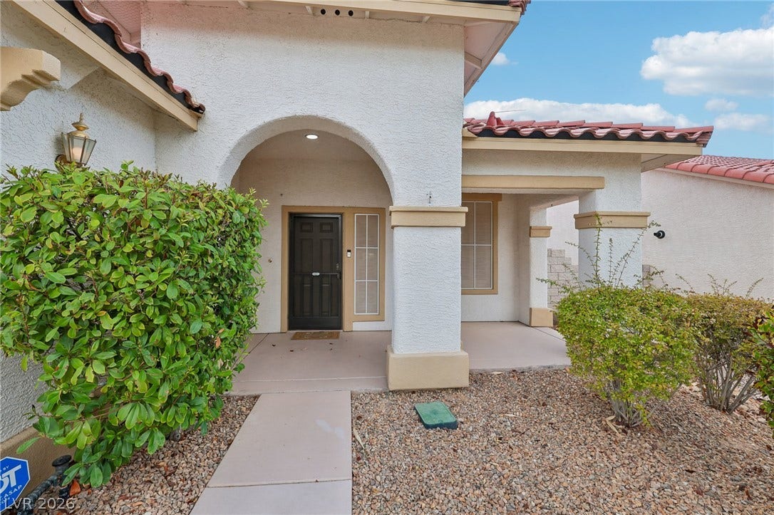 3027 Panorama Ridge Drive, Henderson, NV 89052 An arched covered entryway welcomes guests into this elegant stucco home.