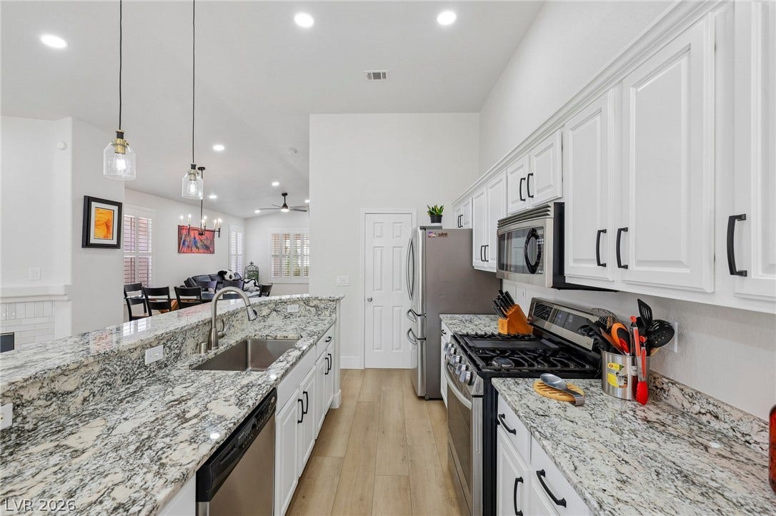 3027 Panorama Ridge Drive, Henderson, NV 89052 Gleaming granite countertops accent this open culinary space featuring recessed lighting and durable wood flooring.