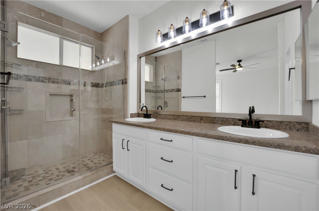 3027 Panorama Ridge Drive, Henderson, NV 89052 Clean lines and a spacious dual vanity highlight this updated bathroom with tiled walk-in shower.