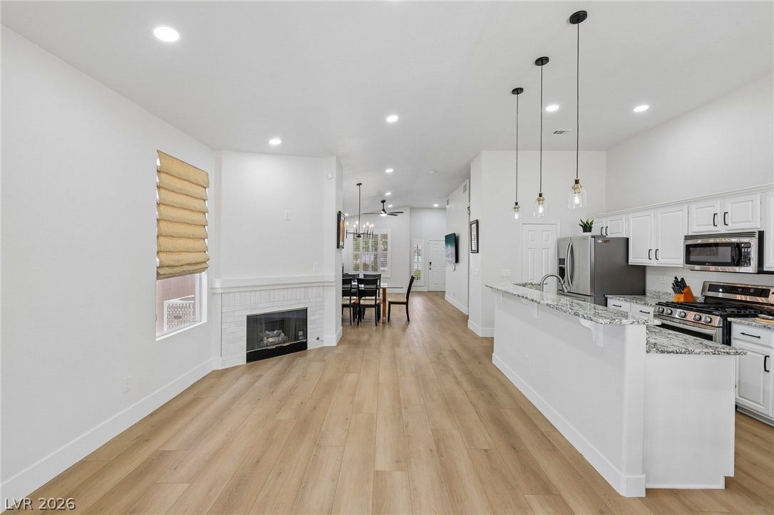 3027 Panorama Ridge Drive, Henderson, NV 89052 An open floorplan seamlessly connects the living space and kitchen over light wood-like flooring.