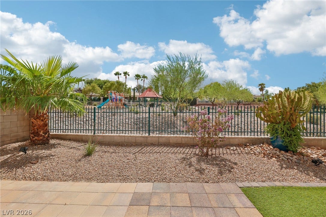 3027 Panorama Ridge Drive, Henderson, NV 89052 Wrought Iron fencing frames views of the natural preserve playground and surrounding greenery from this paved patio.