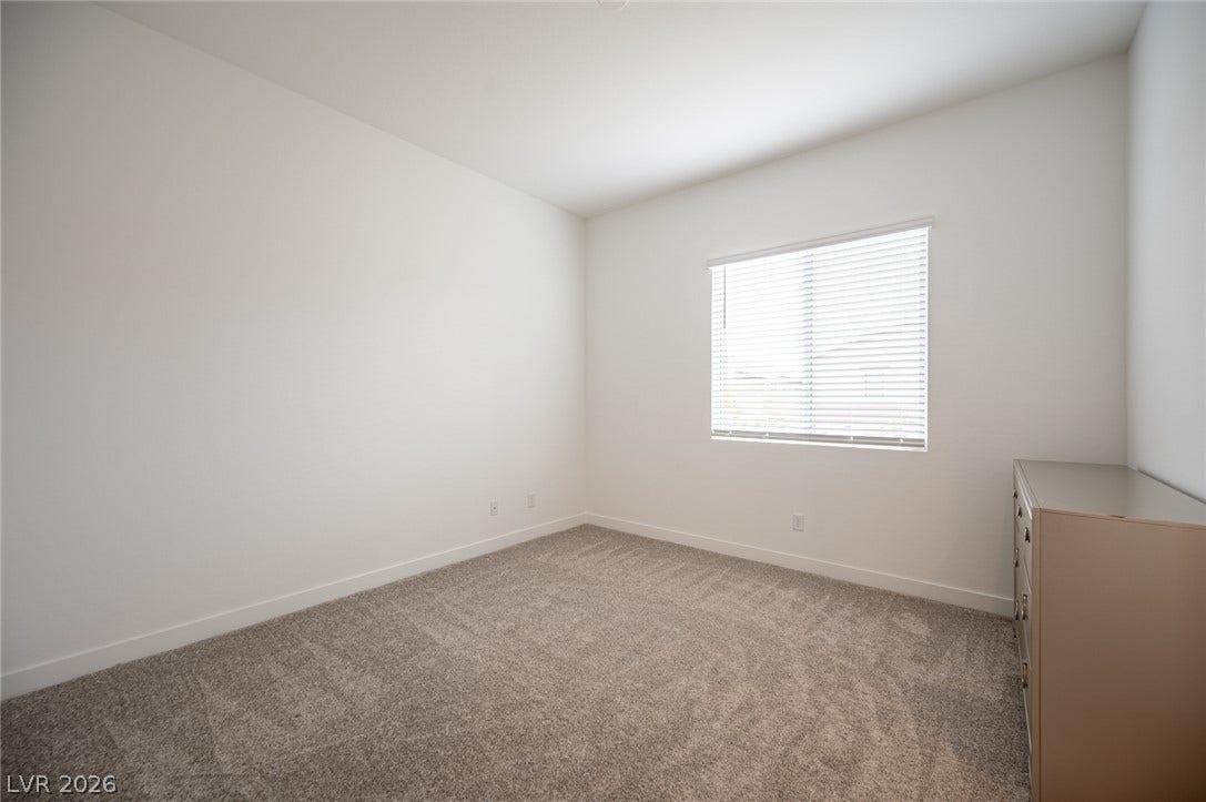 3904 Aiden Creek Avenue, North Las Vegas, NV 89031 Plush carpeting and a single window define this versatile bedroom.